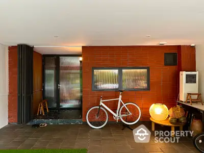 Stylish modern entrance with brick wall, bicycle, and unique lighting