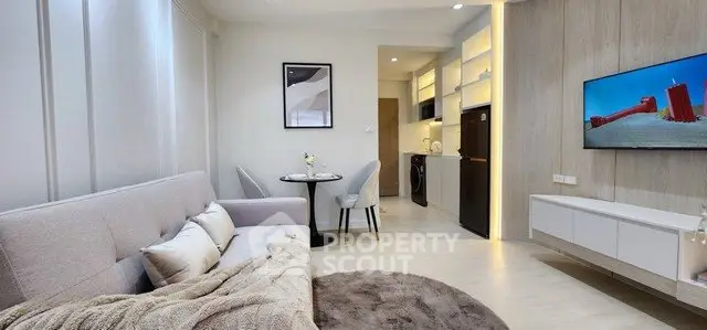 Modern living room with cozy seating, stylish decor, and open kitchen layout.