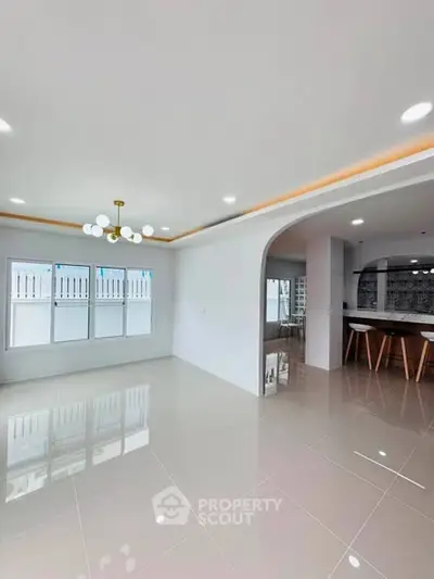 Spacious modern living room with elegant lighting and glossy tiled floors