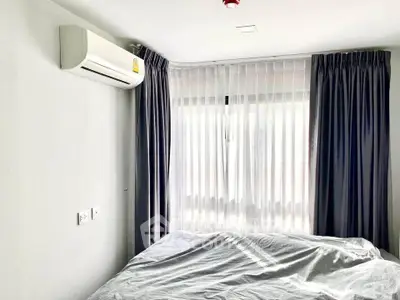 Cozy bedroom with air conditioning and large window with curtains.