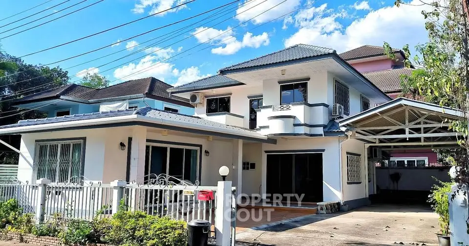 Charming two-story house with spacious driveway and lush garden, perfect for family living.