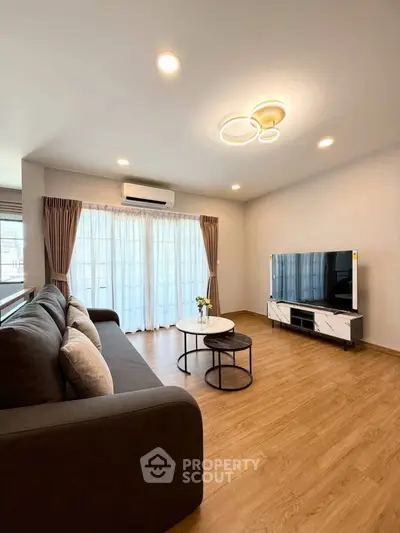 Spacious modern living room with elegant lighting and large windows.