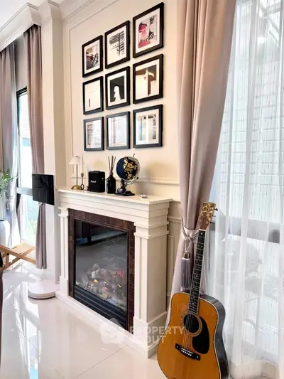 Elegant living room with fireplace, guitar, and framed art, featuring large windows and soft drapes.