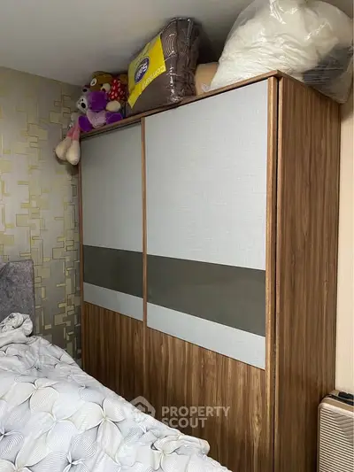 Cozy bedroom with modern wardrobe and plush bedding, perfect for stylish living.