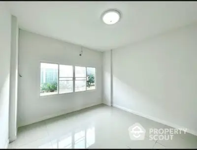 Bright empty room with large window and glossy tiled floor