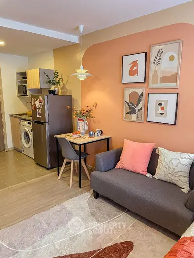 Cozy living room with modern kitchen, stylish decor, and compact dining area in open layout apartment.