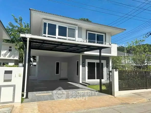 Modern two-story house with carport and landscaped front yard in a serene neighborhood.