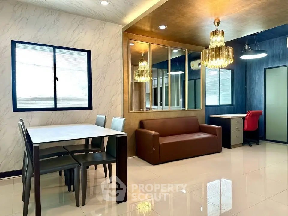 Modern living room with elegant chandelier and stylish furniture in a contemporary apartment.