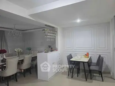 Elegant dining area with chandelier and modern decor in a spacious open-plan layout.