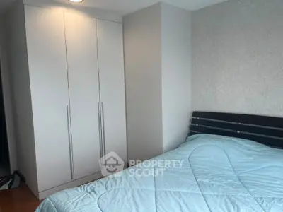 Cozy bedroom with modern wardrobe and stylish wallpaper, perfect for a comfortable living space.