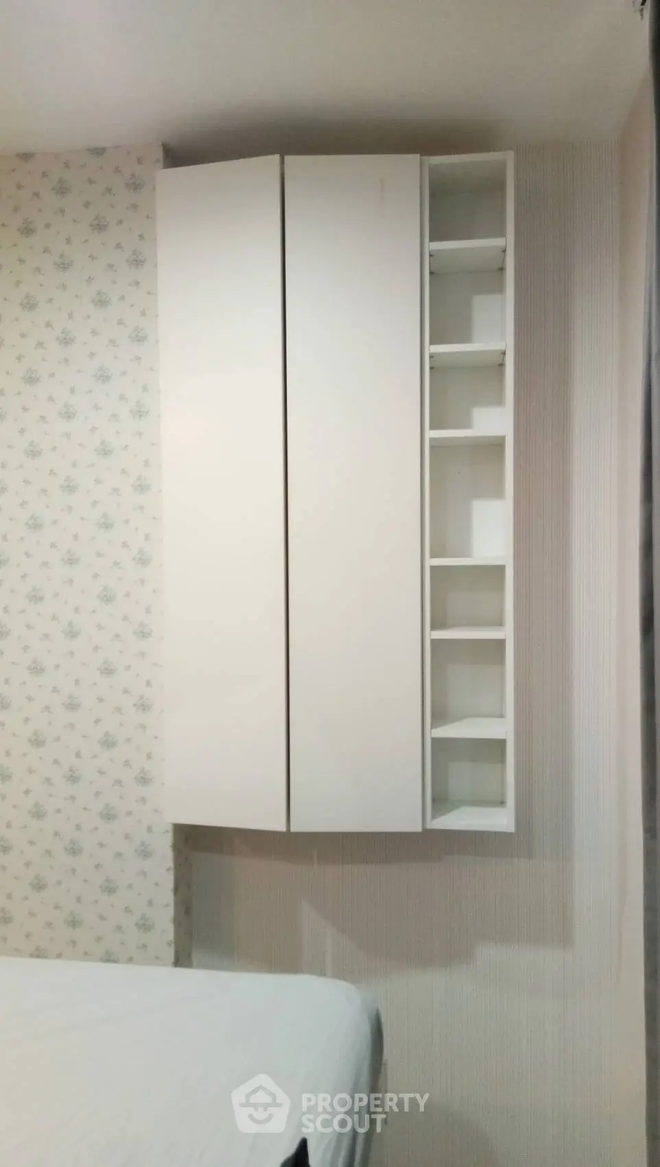 Cozy bedroom with modern white storage cabinets and floral wallpaper