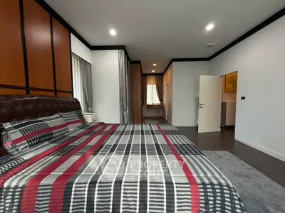 Spacious modern bedroom with stylish decor and ample natural light