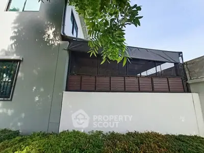 Modern building exterior with lush greenery and stylish balcony