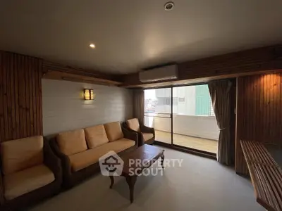 Cozy living room with wooden accents and large sliding glass doors to balcony.