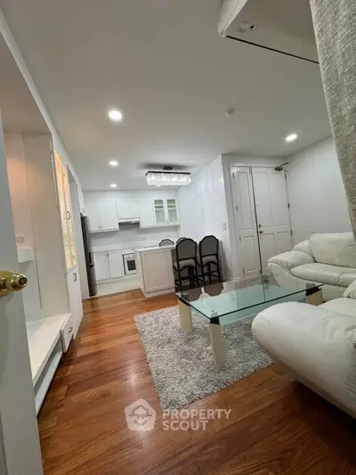 Modern open-layout living room with elegant kitchen and stylish furnishings.