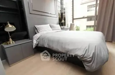 Modern bedroom with stylish decor and large window offering natural light.