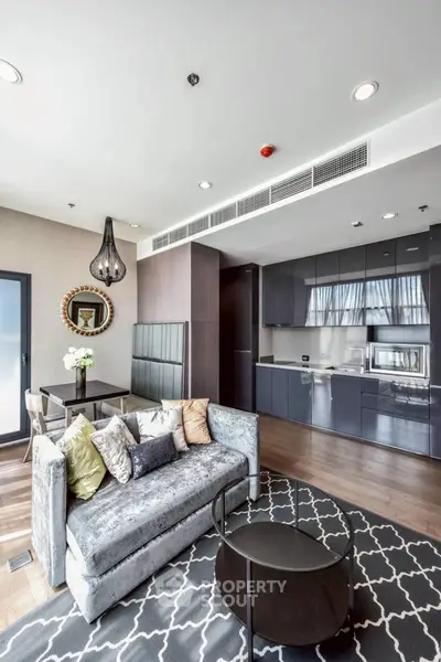 Modern living room with sleek kitchen and stylish decor in luxury apartment.
