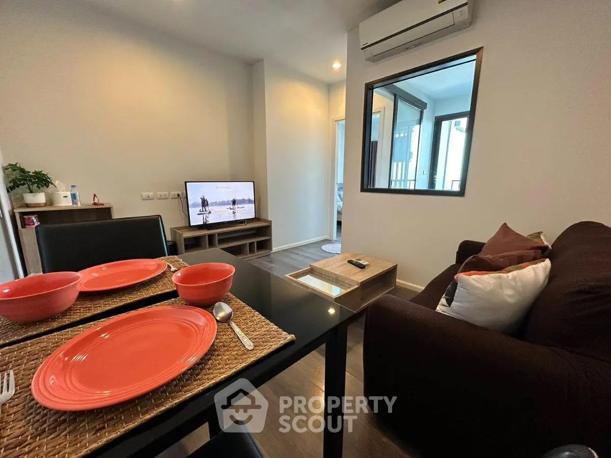 Cozy living room with dining area, modern decor, and air conditioning in a stylish apartment.