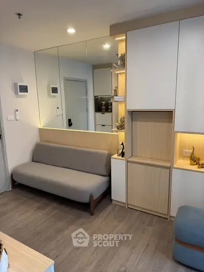 Modern living room with sleek furniture and ambient lighting, featuring a cozy sofa and stylish storage solutions.