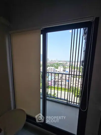 Modern apartment balcony with stunning city view and sleek sliding glass doors.