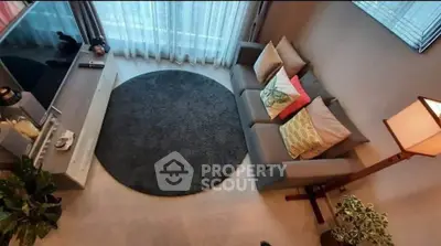 Modern living room with cozy sofa, stylish decor, and large window for natural light.