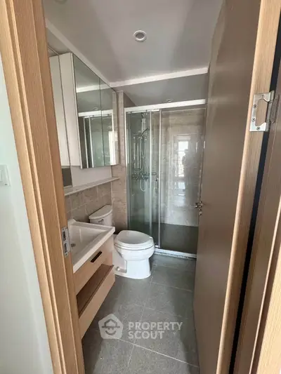 Modern bathroom with glass shower and sleek fixtures in a contemporary apartment.