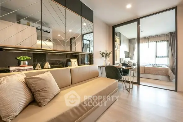 Modern living room with mirrored wall and cozy seating area in stylish apartment.