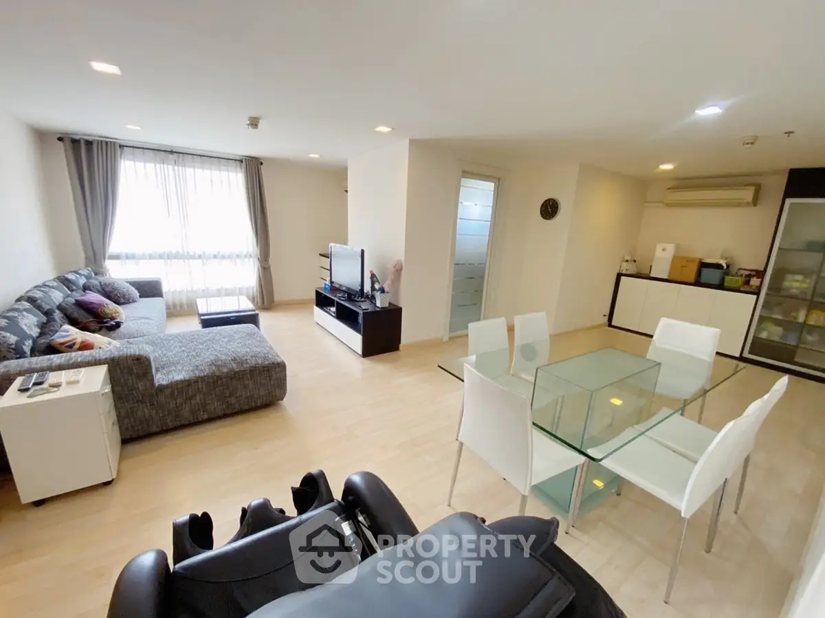 Spacious modern living room with dining area and large windows in a stylish apartment.