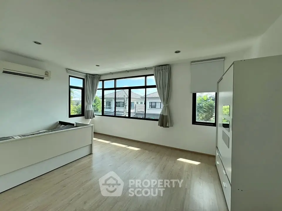 Spacious and bright living room with large windows and modern flooring