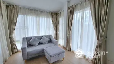 Bright corner living room with elegant curtains and cozy gray sofa