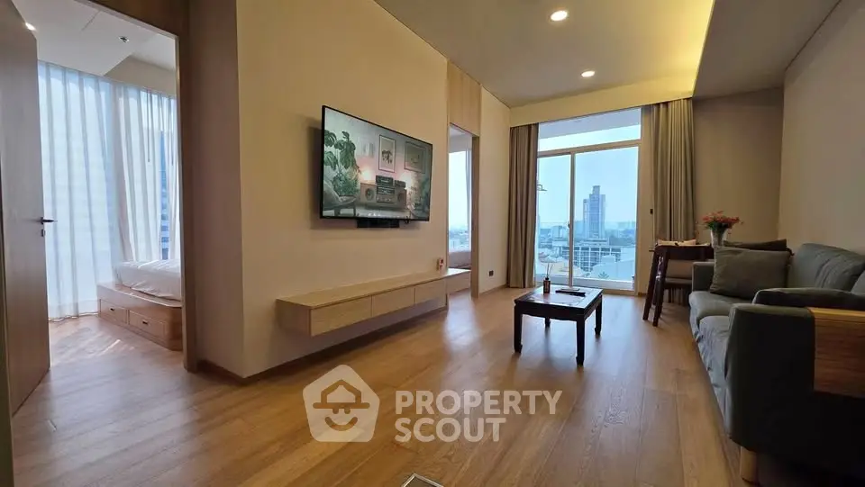 Modern living room with city view, wooden flooring, and stylish furniture in a high-rise apartment.