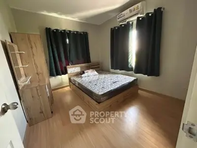 Cozy bedroom with wooden flooring and modern furnishings, perfect for relaxation.