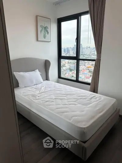 Cozy bedroom with city view, featuring a single bed and elegant decor, perfect for urban living.