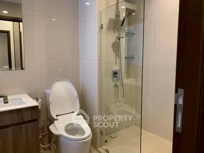Modern bathroom with sleek shower and smart toilet in contemporary design.