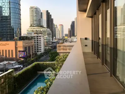 Stunning cityscape view from a modern balcony overlooking a lush pool and urban skyline.