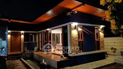 Modern single-story home with stylish exterior lighting and wooden accents at night.