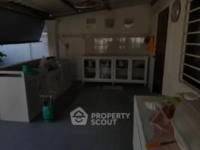 Spacious outdoor kitchen with ample storage and tiled flooring, perfect for entertaining guests.