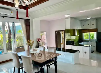 Spacious dining area with elegant decor and modern kitchen in open layout design.