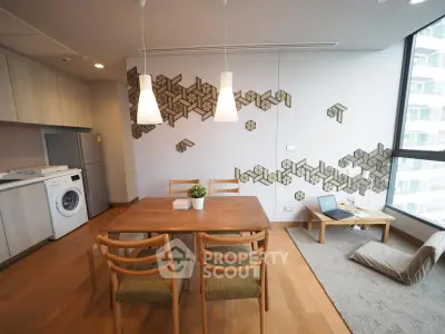 Modern dining area with wooden table, chairs, and unique wall art in a cozy apartment.