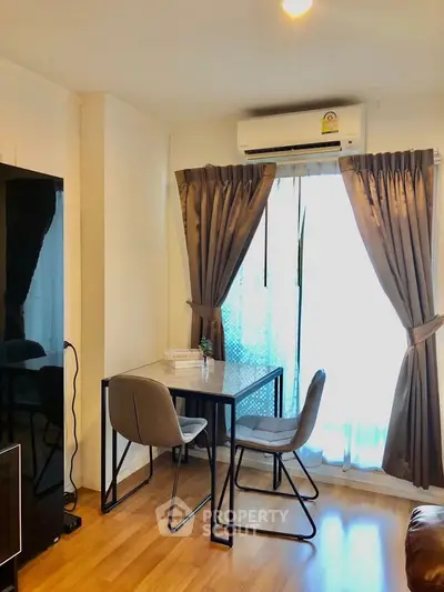 Cozy living room with modern furniture and natural light, featuring a stylish dining area and elegant curtains.