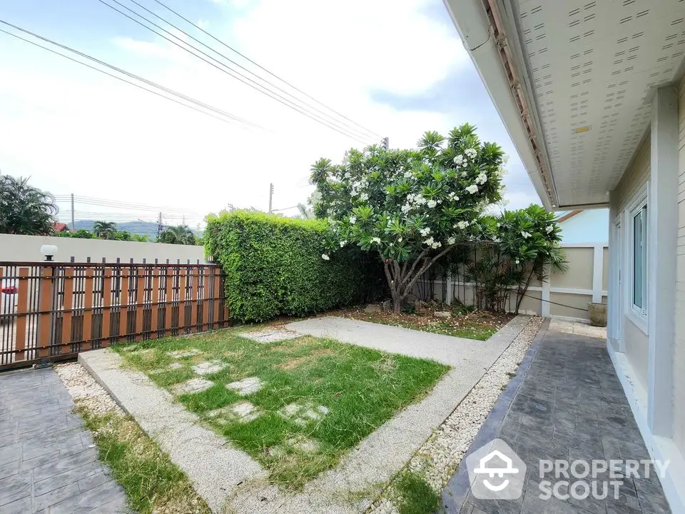 Charming garden view with lush greenery and modern fence in a serene residential area.