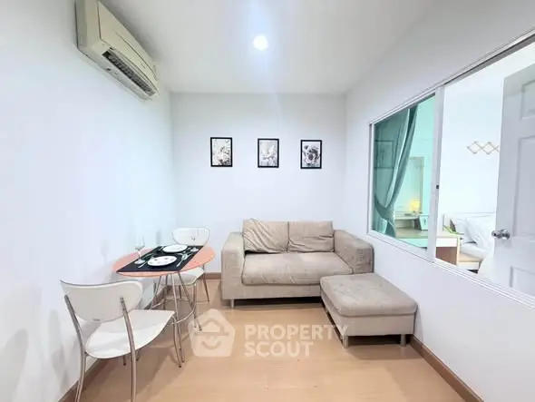 Cozy living room with modern decor and air conditioning, perfect for relaxation.