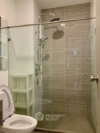 Modern bathroom with glass shower and sleek fixtures in a contemporary apartment.