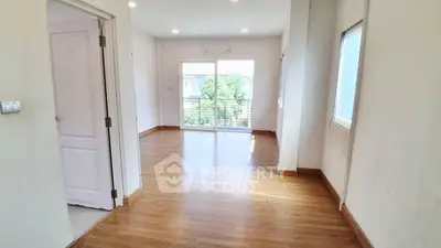 Spacious and bright living room with large windows and wooden flooring