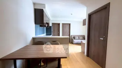 Modern apartment interior with open layout, featuring a cozy living area and sleek kitchen design.