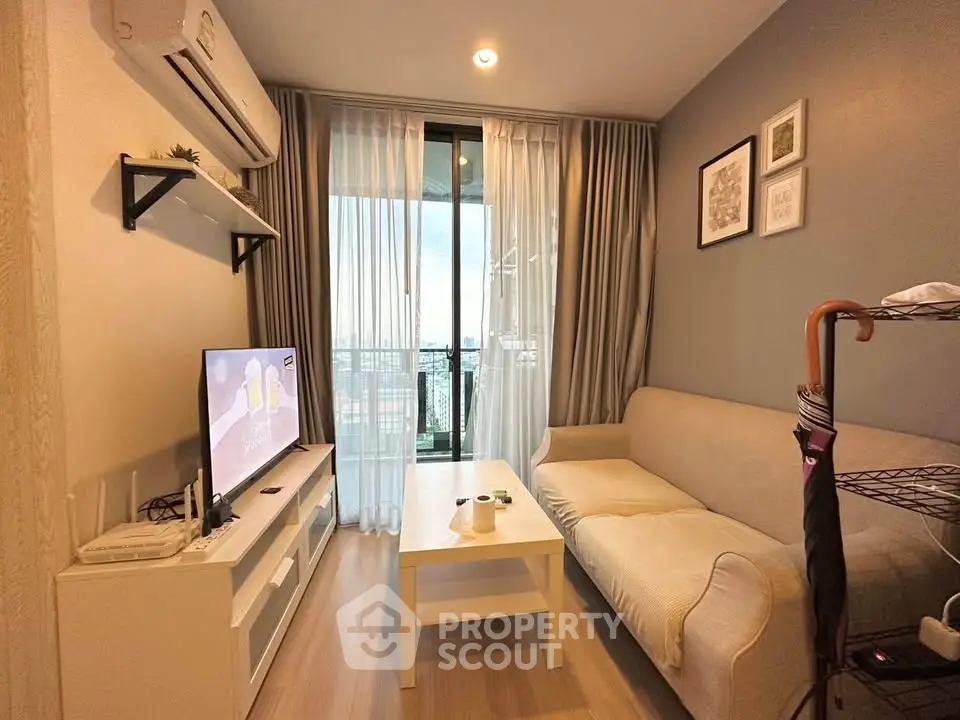 Cozy living room with modern decor and city view balcony, perfect for relaxation.