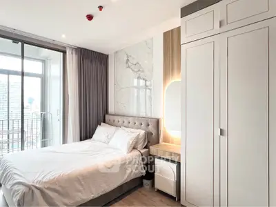 Modern bedroom with city view, featuring elegant decor and ample natural light.