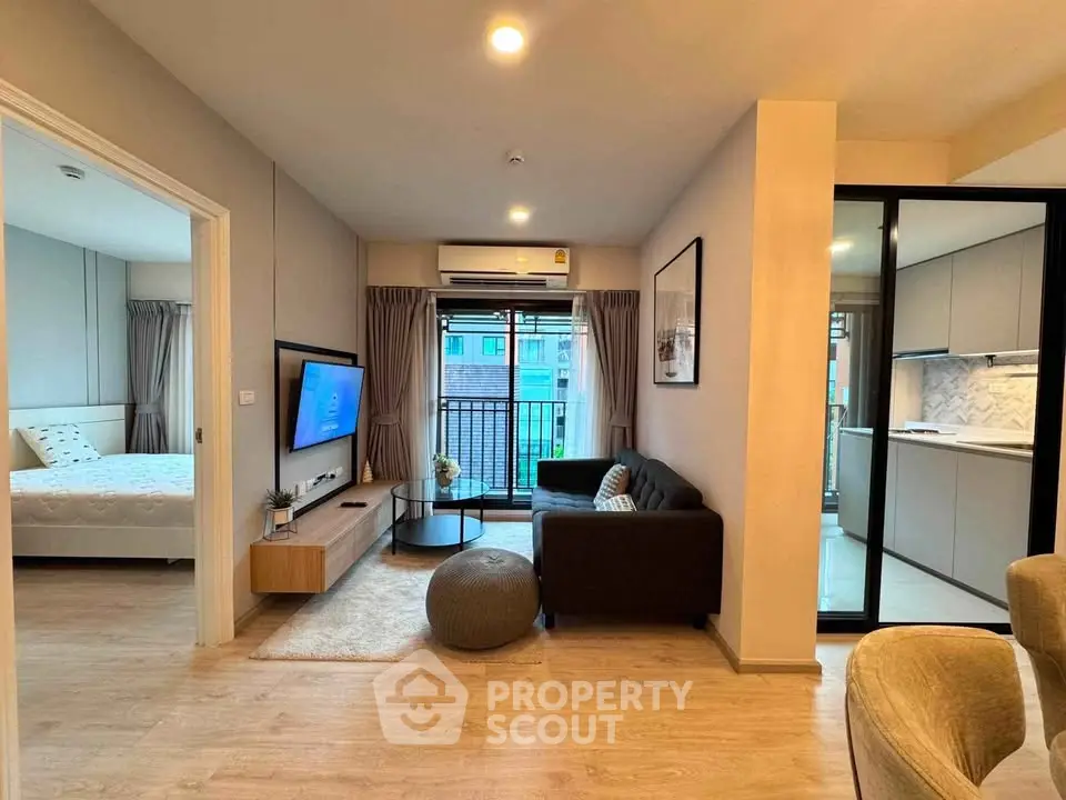 Modern apartment living room with open kitchen and cozy bedroom view.