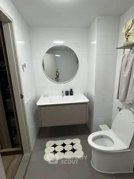 Modern bathroom with round mirror and sleek fixtures
