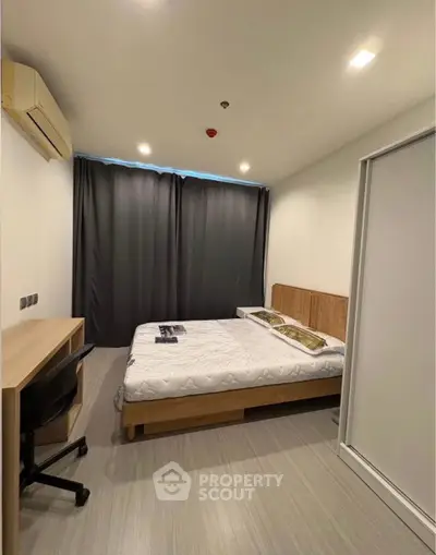 Modern bedroom with minimalist design, featuring a cozy bed, study desk, and sleek flooring.